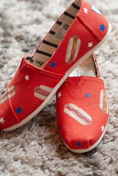 Red shoes with hot dog design on a textured surface
