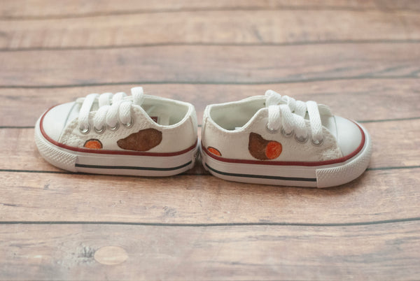 White low top converse with sweet potatoes painted on the sides. 
