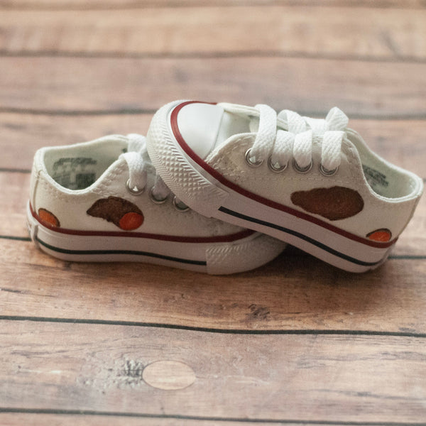 White low top converse with sweet potatoes painted on the sides. 