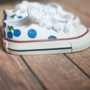 White sneakers with blueberry design on a wooden floor