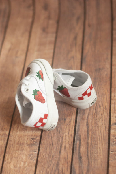 White vans sneakers with strawberry designs on a wooden floor