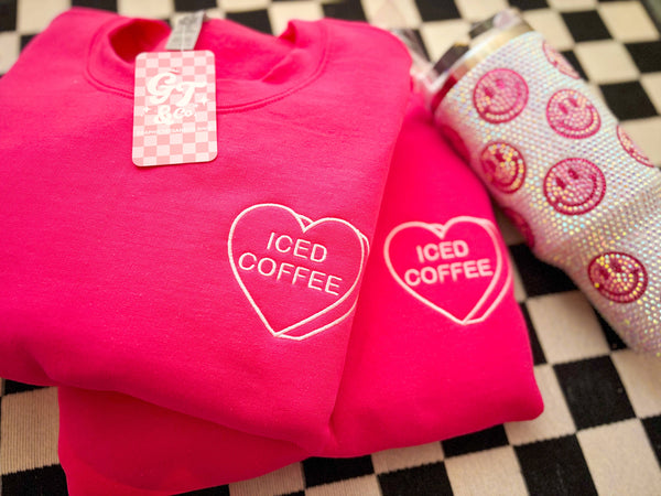Pink sweatshirt with 'ICED COFFEE' design on a checkered surface